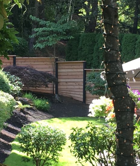 Stepped cedar fence with black posts